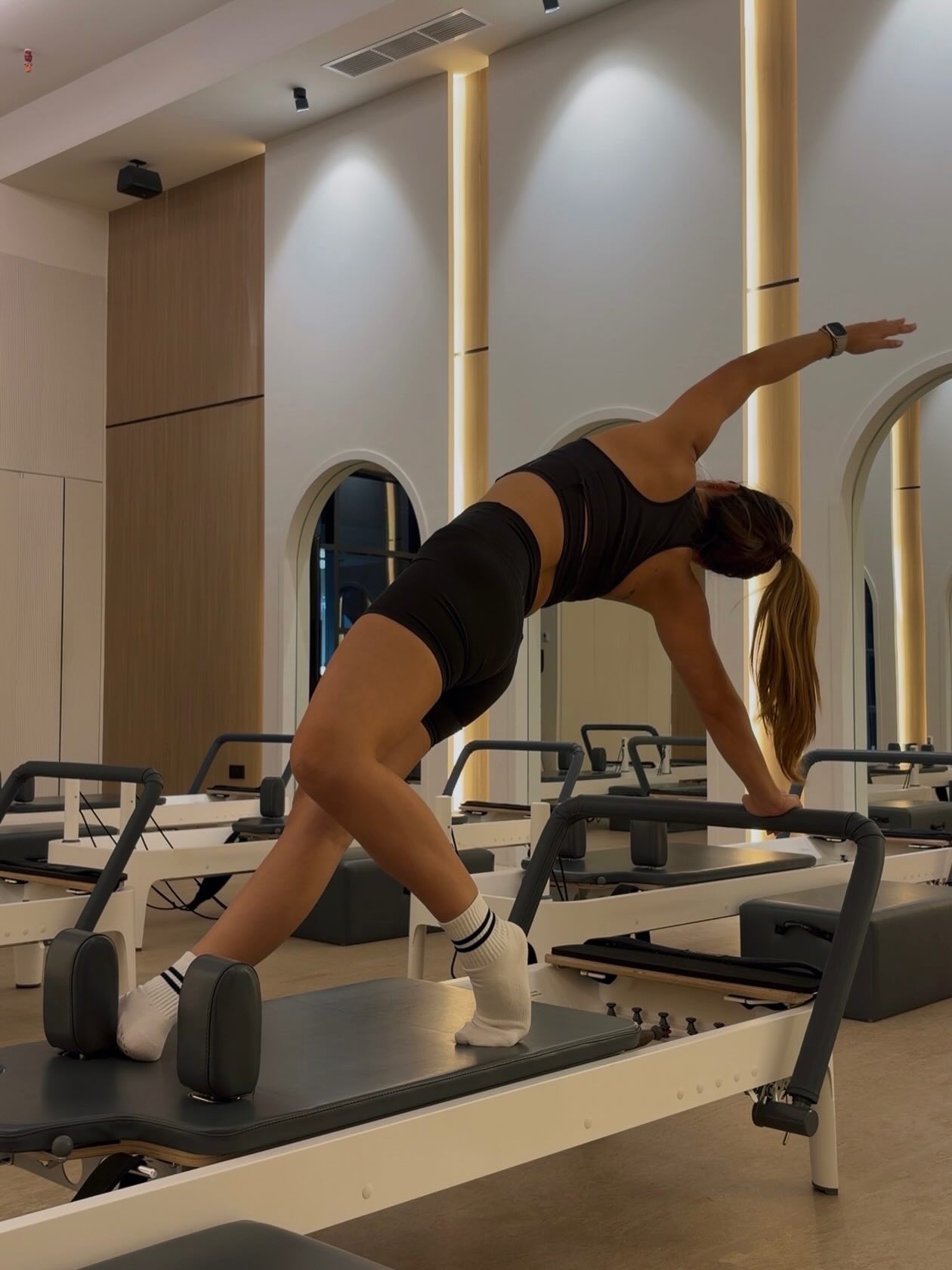 Alyson Fajardo performing Reformer Pilates exercise in boutique studio
